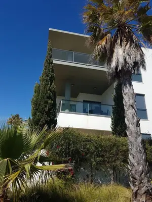 a building with a palm tree in front of it at Cavalo Prеto Holiday apartment 200m to the beach in Quarteira