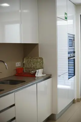 a kitchen with white cabinets and a sink at Cavalo Prеto Holiday apartment 200m to the beach in Quarteira