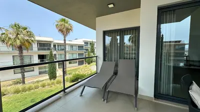a balcony with two chairs and a view of a building at Cavalo Prеto Holiday apartment 200m to the beach in Quarteira