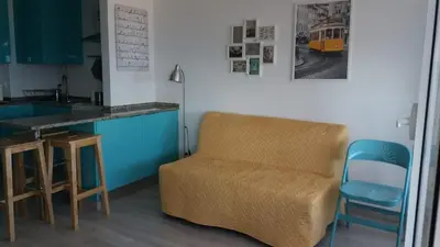 a living room with a chair and a table and a counter at Edifício Albufeira 406 in Albufeira