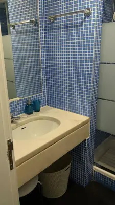 a bathroom with a sink and a blue tiled wall at Edifício Albufeira 406 in Albufeira