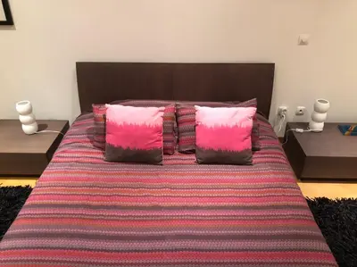 a bedroom with a bed with pink and purple pillows at Your place in Faro in Faro