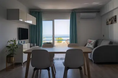 a living room with a table and chairs with a view at Apartamento Deluxe AM in Quarteira