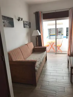 a living room with a couch and a window at Zesty Orange by ITHOUSE in Albufeira