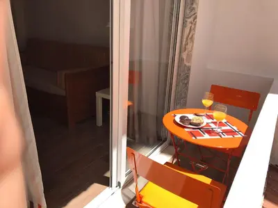 a small table with a plate of food and two glasses of wine at Zesty Orange by ITHOUSE in Albufeira