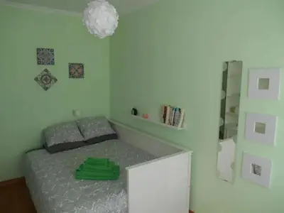 a bedroom with a bed with a green shirt on it at AL - Comfortable House in Faro