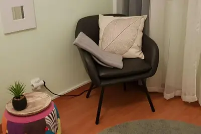 a black chair with a pillow on it in a room at AL - Comfortable House in Faro