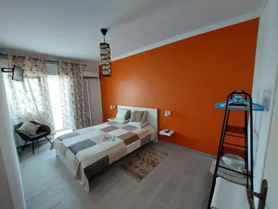 a bedroom with a bed with an orange wall at AL - Comfortable House in Faro