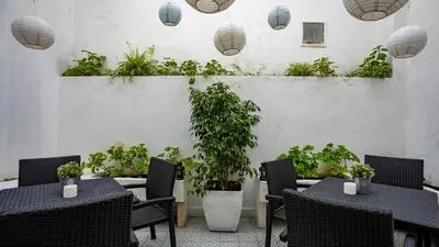 a restaurant with tables and chairs and potted plants at Hostel Casa d'Alagoa in Faro