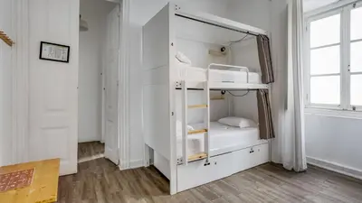 a white bunk bed in a room with a window at Hostel Casa d'Alagoa in Faro