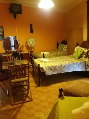a living room with two beds and a chair at Guest House Pacifica in Quarteira