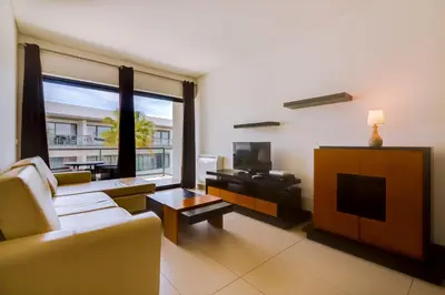 a living room with a couch and a tv at Cavalo Preto Beach Resort in Quarteira