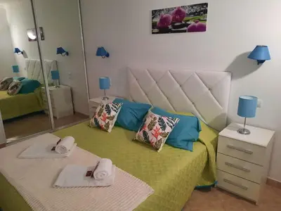 a bedroom with a bed with towels and a mirror at venha nadar a oura in Albufeira