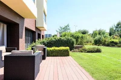 a patio with wicker chairs and a lawn at L'Orangerie in Vilamoura