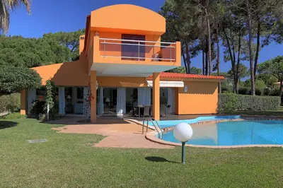 a house with a balcony next to a swimming pool at Casa da Palmeira, pool & soccer pitch in Vilamoura