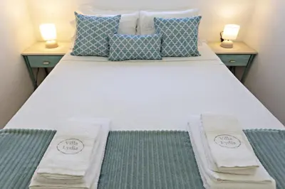 a bedroom with a white bed with two night stands at Villa Lydia in Faro