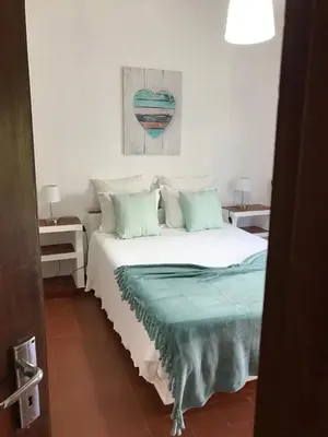 a bedroom with a large white bed with blue pillows at BREEZY NEST by ITHOUSE in Albufeira