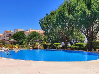 a large blue swimming pool with trees and buildings at Fabulous Sunny Pool&Garden Condo by BeCherish in Albufeira