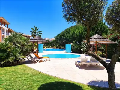a pool with chairs and umbrellas in a yard at Fabulous Sunny Pool&Garden Condo by BeCherish in Albufeira