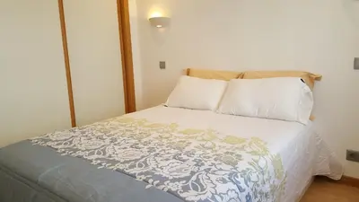 a bed with a blue and white blanket and pillows at Apartamento Cardoso II. A 5 minuto a pé da praia do Peneco in Albufeira