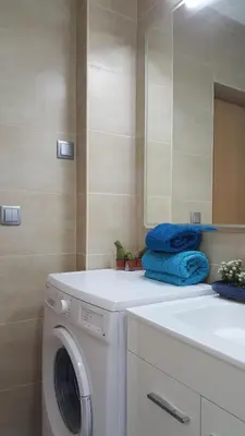 a bathroom with a washing machine and a mirror at Apartamento Cardoso II. A 5 minuto a pé da praia do Peneco in Albufeira