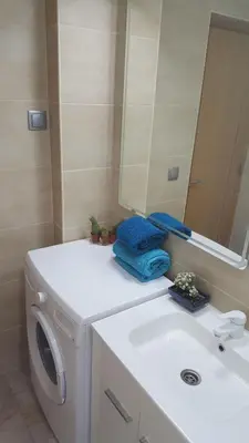 a bathroom with a washing machine and a sink at Apartamento Cardoso II. A 5 minuto a pé da praia do Peneco in Albufeira