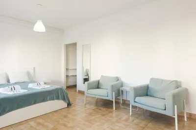 a bedroom with two chairs and a bed at Sea Studio in Quarteira