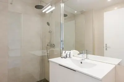 a white bathroom with a sink and a shower at Sea Studio in Quarteira