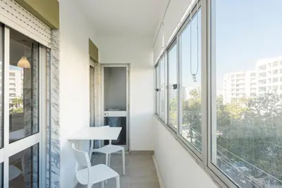 a balcony with a table and chairs and windows at Sea Studio in Quarteira