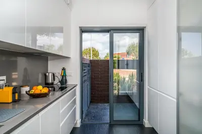 a kitchen with white cabinets and a sliding glass door at Vilamoura Charming Apartment by Intiholidays in Vilamoura