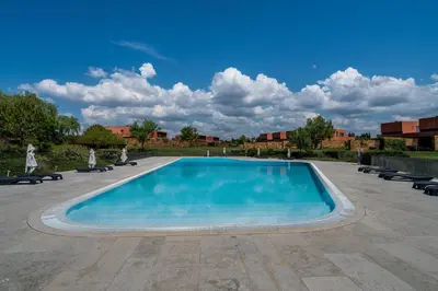 a large swimming pool with chairs and a blue sky at Vilamoura Charming Apartment by Intiholidays in Vilamoura
