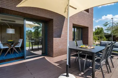 a patio with a table and chairs and an umbrella at Vilamoura Charming Apartment by Intiholidays in Vilamoura