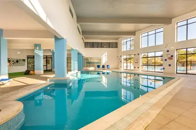 a large swimming pool with blue water in a building at Panoramic Sea View 1 Bedroom Apartment in Albufeira