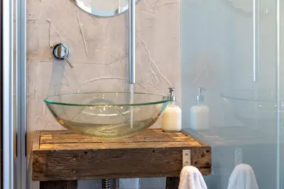 a glass bowl on a wooden table in a bathroom at Edifício Algarve in Quarteira