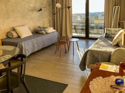 a living room with two beds and a balcony at Edifício Algarve in Quarteira