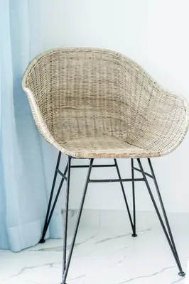 a rattan chair sitting in front of a curtain at Victory Village 1B Quinta do Lago in Quinta do Lago