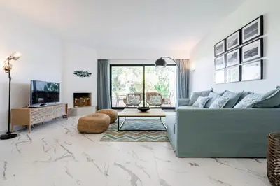 a living room with a blue couch and a tv at Victory Village 1B Quinta do Lago in Quinta do Lago
