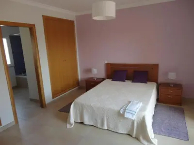 a bedroom with a large bed with blue pillows at Villa 48 in Quarteira