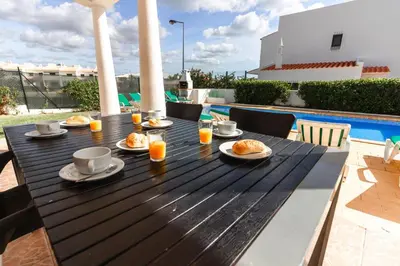 a wooden table with food and drinks on a patio at Villa 300m from Beach - By Algarkasa in Albufeira