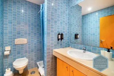 a blue tiled bathroom with a toilet and a sink at Corcovada B42 - Dream Lodging in Albufeira