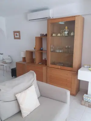a living room with a couch and a wooden cabinet at A Apartmento Solar dos Pinheiros in Vilamoura