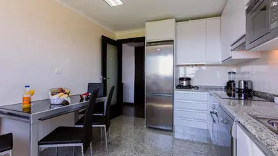 a kitchen with white cabinets and a stainless steel refrigerator at Monte Laguna Duplex - Greice Homes in Vilamoura