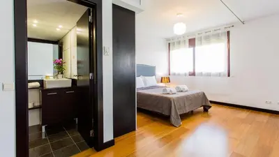 a bedroom with a bed and a bathroom with a mirror at Monte Laguna Duplex - Greice Homes in Vilamoura