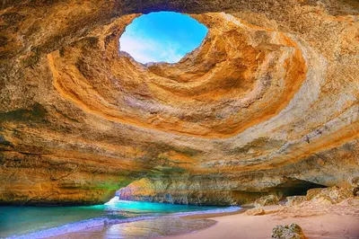 a rock formation with a hole in it next to a body of water at Apartment Coelha Beach - Pool - Free Wi-Fi - Air Con in Albufeira