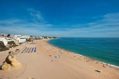 a beach with a bunch of people and the ocean at Apartment Coelha Beach - Pool - Free Wi-Fi - Air Con in Albufeira