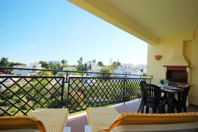 a balcony with a table and chairs and a fireplace at Apartment Coelha Beach - Pool - Free Wi-Fi - Air Con in Albufeira