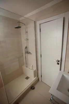 a bathroom with a shower with a glass door at Apartamento A Palmeira in Albufeira