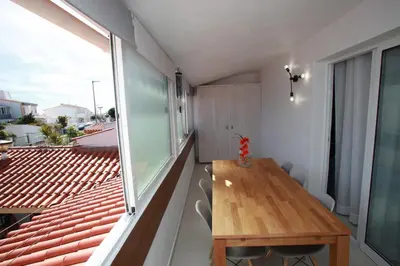 a room with a wooden table and a large window at Apartamento A Palmeira in Albufeira