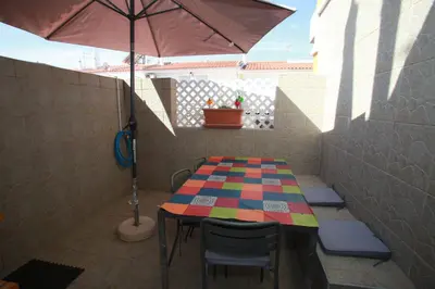 a table and chairs with an umbrella on a patio at Apartamento A Palmeira in Albufeira