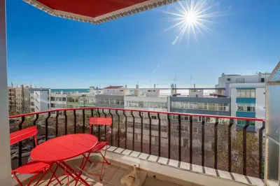 a balcony with red chairs and a view of the city at Vita Portucale ! Quarteira Sea View in Quarteira